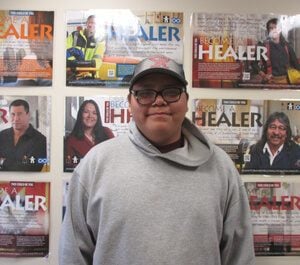 Cooking: Colton smiling, wearing hat glasses and hoodie in front of magazines