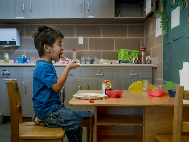Helping here at home: a child eats a healthy meal at school in Neyaashiinigmiing