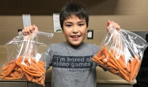 School food ambassador shows off home-grown carrots