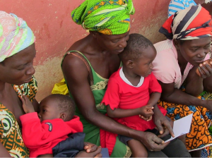 Three women and their children collect their pay-out from a Ghanaian VSLA.