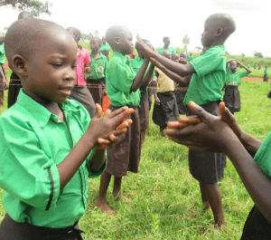 Melan playing a clapping game with a classmate