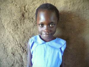 A little girl smiles directly into the camera