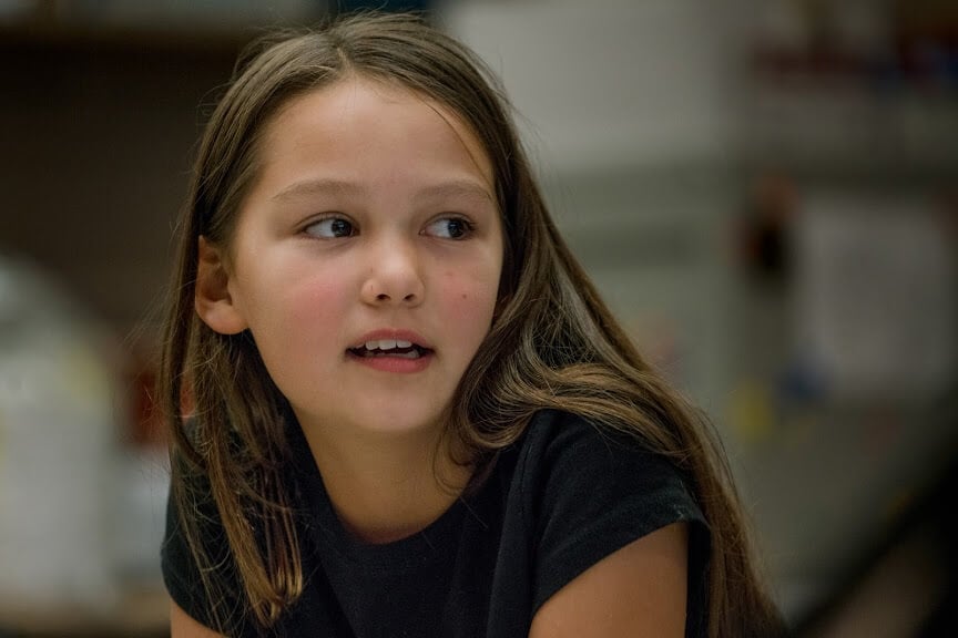 A young girl speaking at a school event