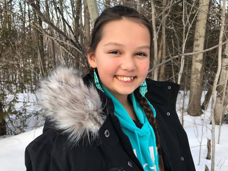 A girl proudly smiles into the camera