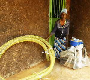 A woman poses with a water pump for the community