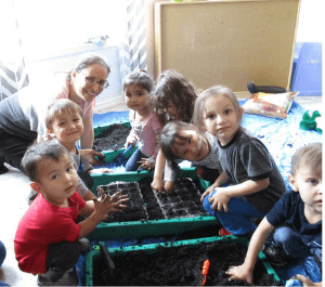 Children planting seeds in classroom garden