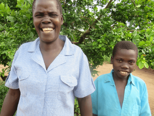 A mother and her son grin widely for the camera