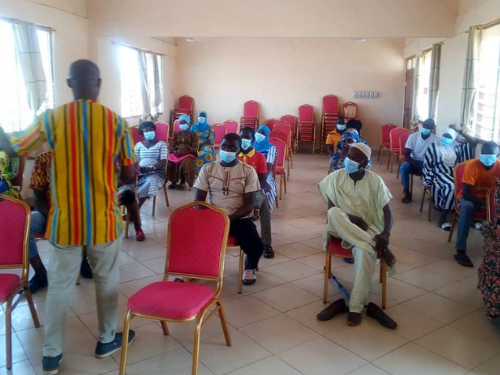 group of community members sitting in masks receiving safety training