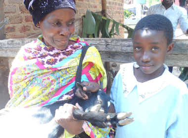 A girl and her grandma hold a goat