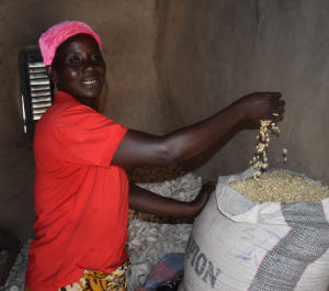 a woman runs her hand through a giant bag of groundnuts