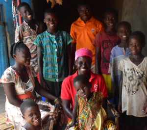 a woman sits in her home surrounded by her kids