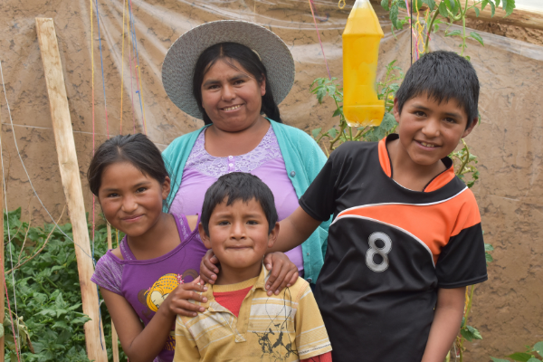 A MOM and her 3 kids smile in their garden