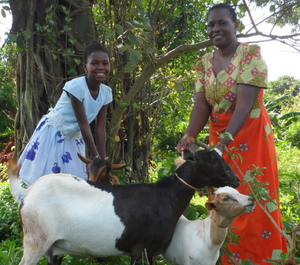 a young girl poses with her grandma and a goat