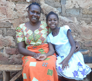 a young girl sits next to her grandmother smiling