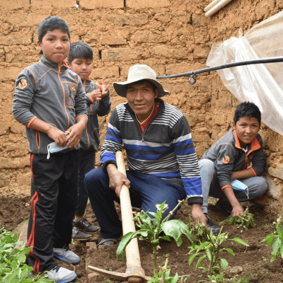 A man crouches in the garden with his three sons.