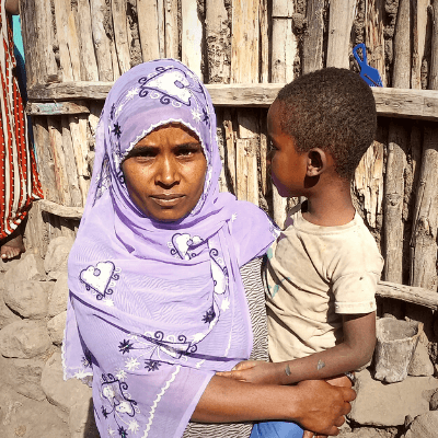 Fatuma holds her son in an outdoor setting