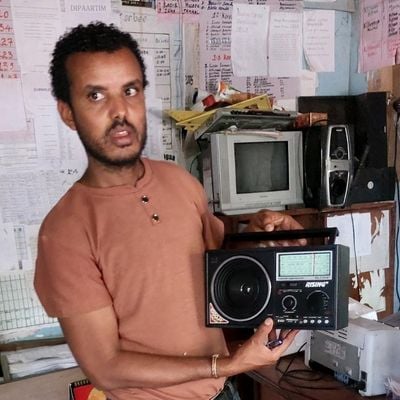 Hassen holds the radio the school received