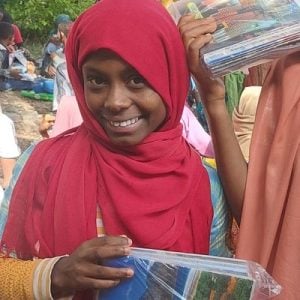 Rabia smiles while holding her package