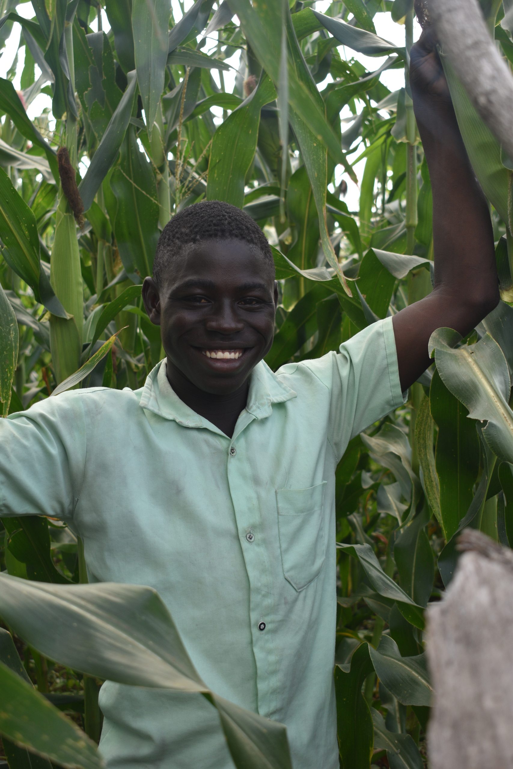 Aliu smiles, posing outdoors.