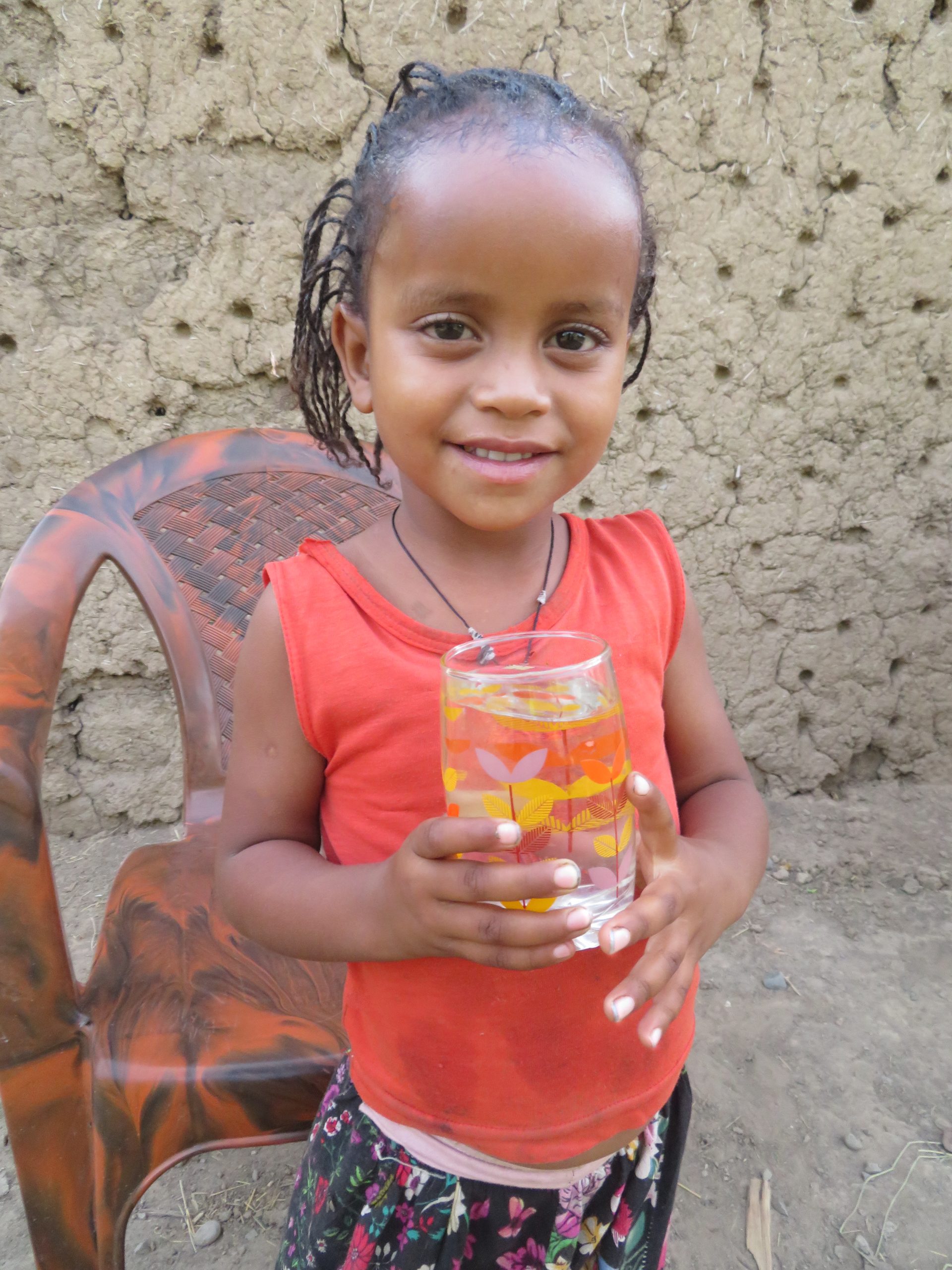 little girl holding a glass of water