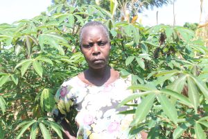 a woman stands in her garden among her produce, looking at the camera