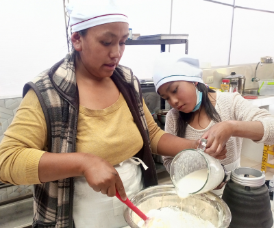 a mother and daughter are baking together and adding ingredients into a bowl