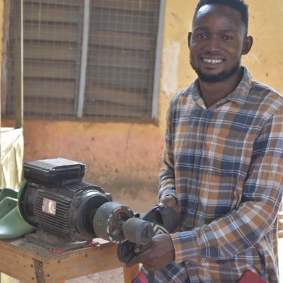 a man stands at a saw making sandals
