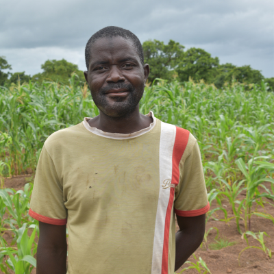 a man stands smiling in his garden