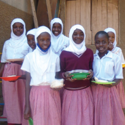 a group of girls smile holding lunch trays