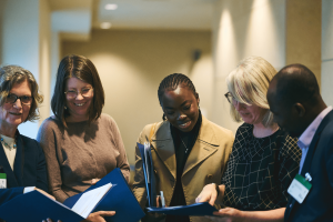 a group of people looking over brochures