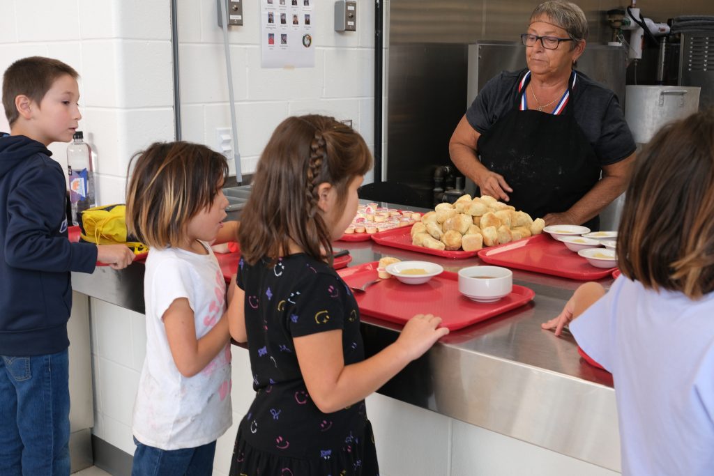 students lining up in cafeteria line to get soup
