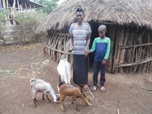 a family smiles holding with their goats