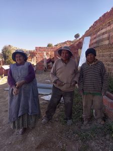 a group of adults stand in their gardens, smiling 