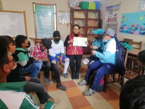 a woman reads a book to children 