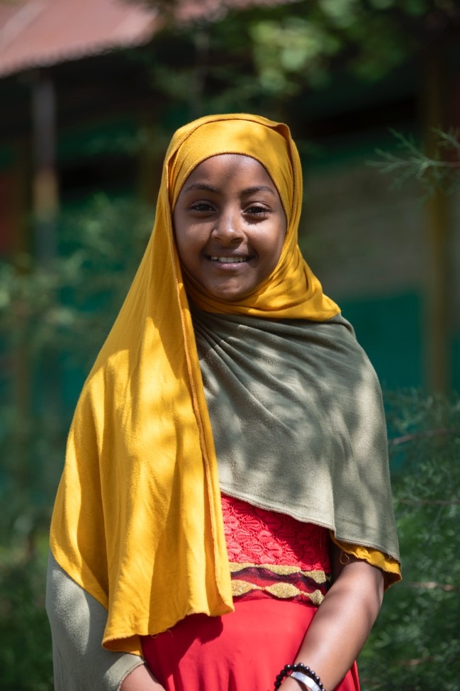 a girl smiles for the cameras