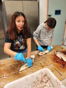 two girls gut caught fish 