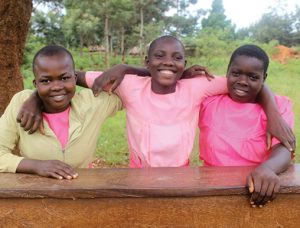 girls with arms around one another, smiling